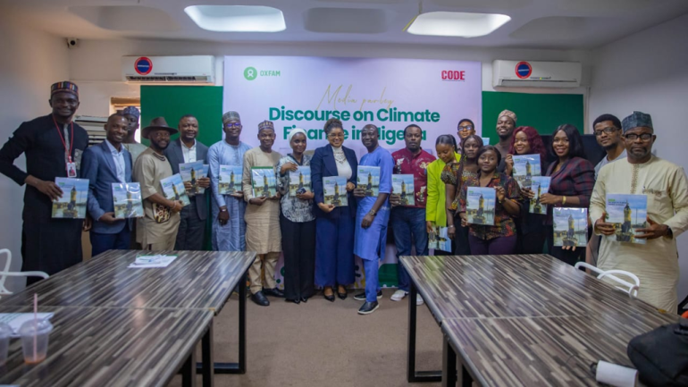Journalists participating in a climate finance training workshop in Abuja, engaging with trainers and taking notes.